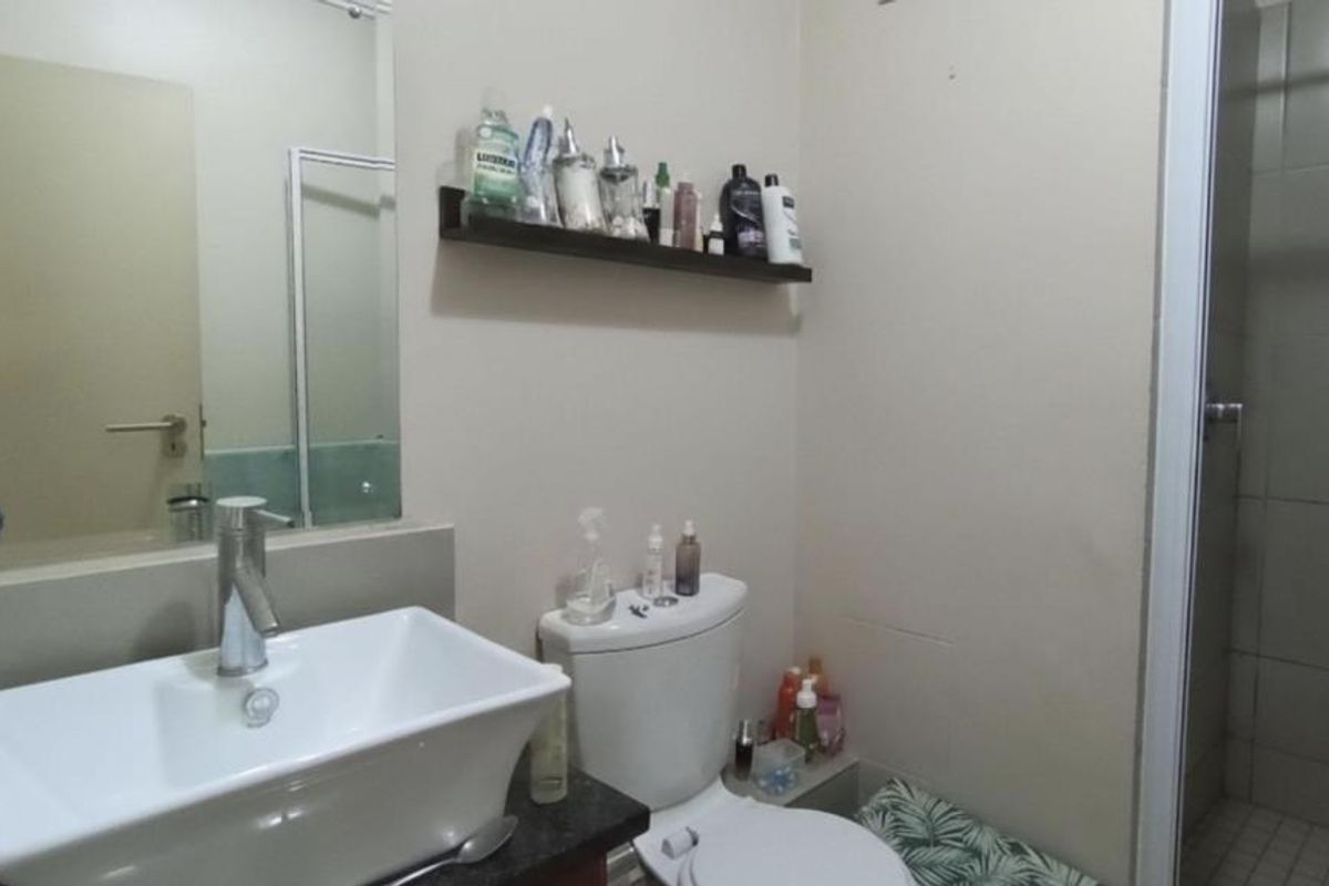 A functional bathroom featuring a modern vessel sink on a granite vanity, a toilet, and a separate shower enclosure with tiled walls.