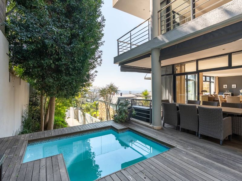 Outdoor entertainment area featuring a plunge pool set into timber decking, adjacent to a covered balcony with access to the main living space.