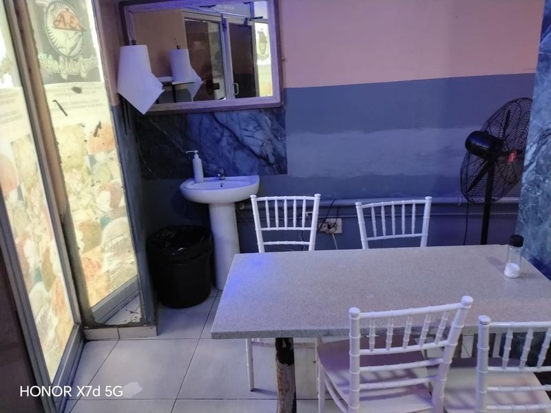 Dining area featuring a pedestal sink, tiled flooring, and wall mirror, requiring cosmetic updates to the wall finishes and electrical presentation.