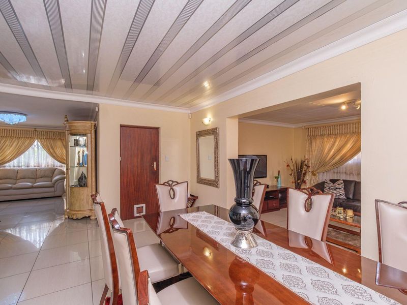 Open plan dining and living area featuring tiled flooring and coved ceilings, creating a connected space for family gatherings and entertaining.