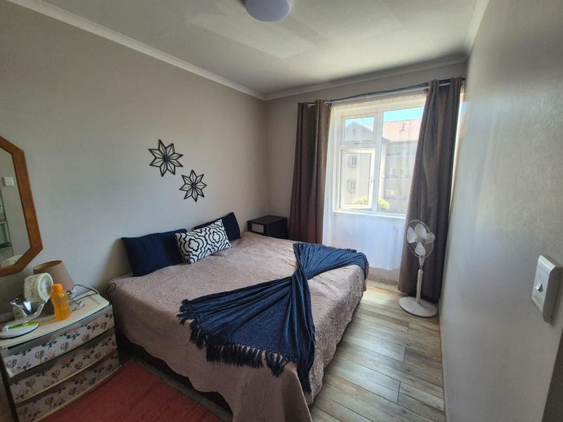 A cozy bedroom featuring laminate flooring and neutral wall finishes, providing a comfortable and functional sleeping space.