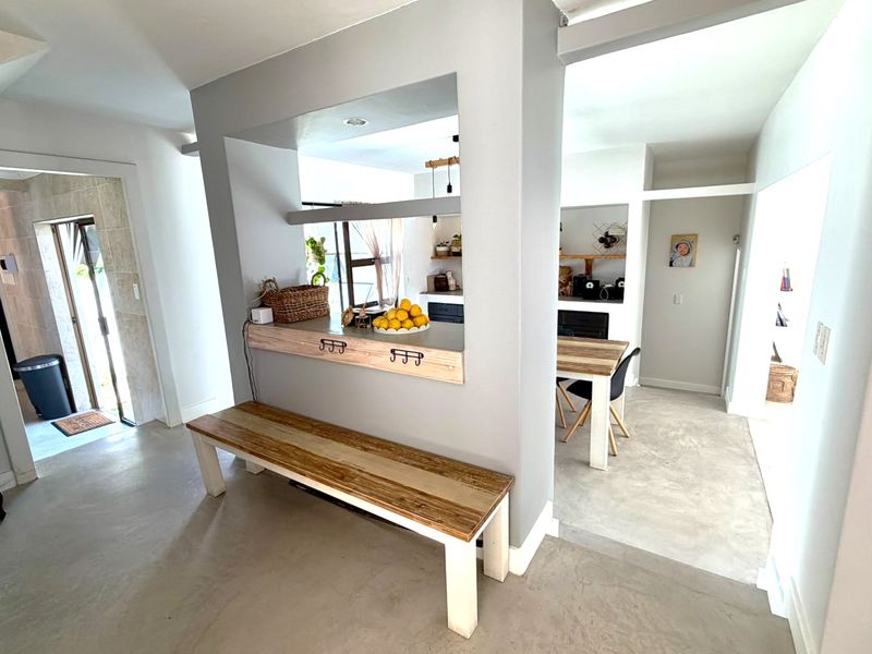 Open plan living area featuring polished concrete floors and a functional pass-through window connecting to the kitchen space.
