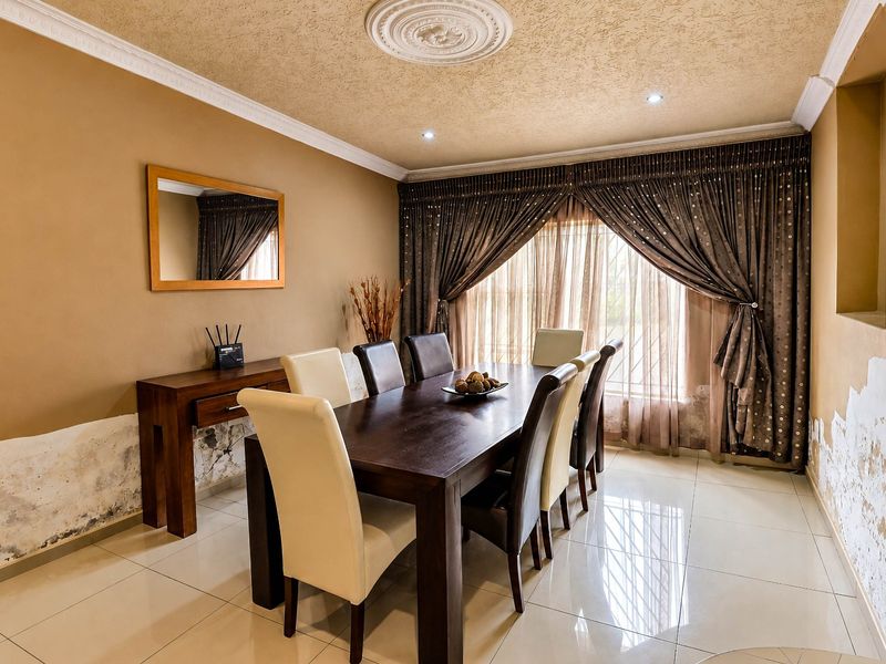 Dining room featuring tiled flooring, recessed lighting, and decorative ceiling rose. Note significant wall damage requiring repair and redecoration.