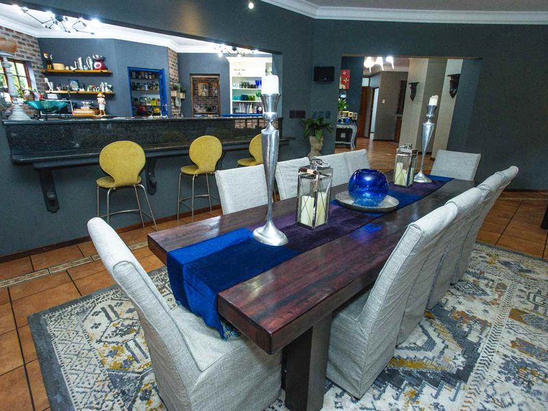 Spacious open-plan dining area featuring tiled flooring, a granite breakfast bar, and an exposed brick feature wall, creating a warm and inviting atmosphere.