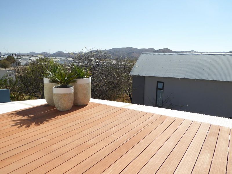 An elevated timber deck balcony offering expansive views of the surrounding landscape and neighboring properties.