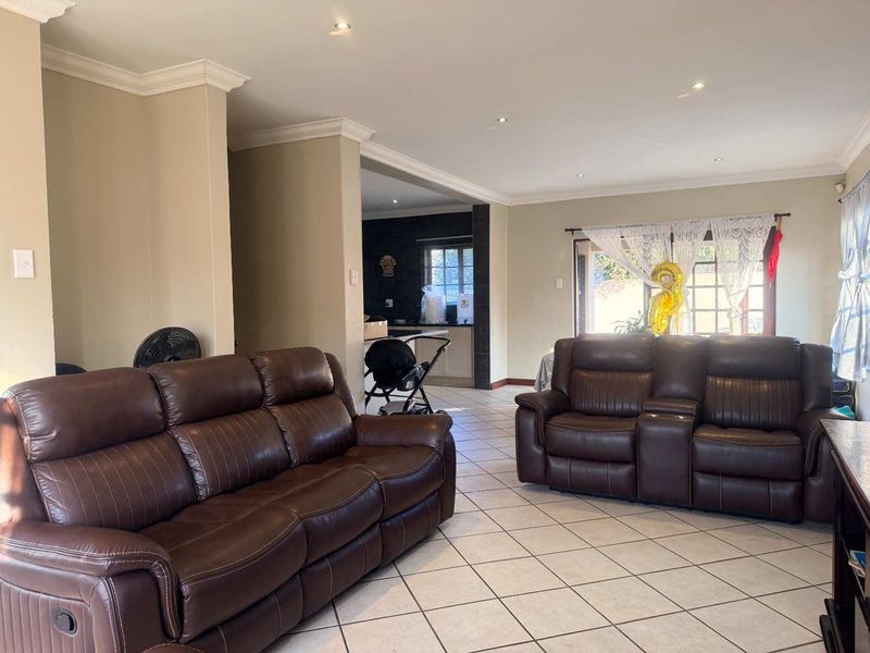 Open plan living area featuring tiled flooring, recessed downlighting, and access to the outdoor area through a sliding glass door.
