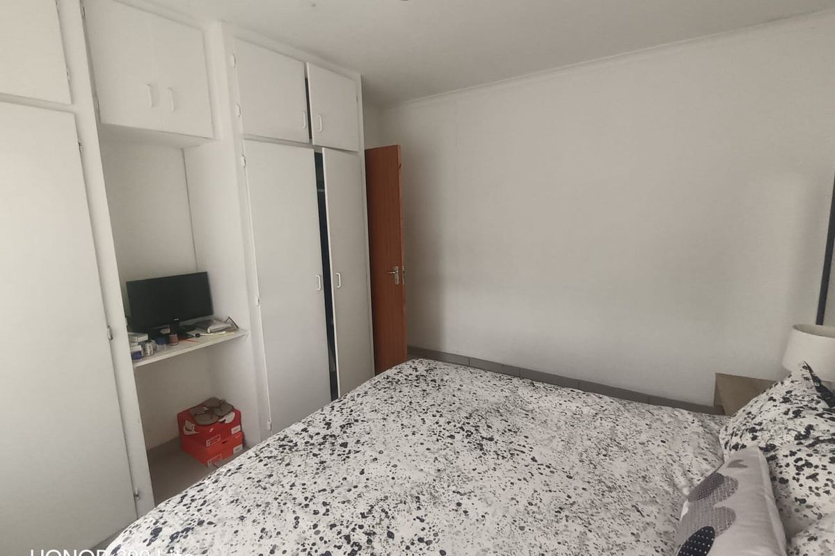 A functional bedroom featuring white built-in cupboards and neutral wall finishes, offering a clean and simple space for personalization.