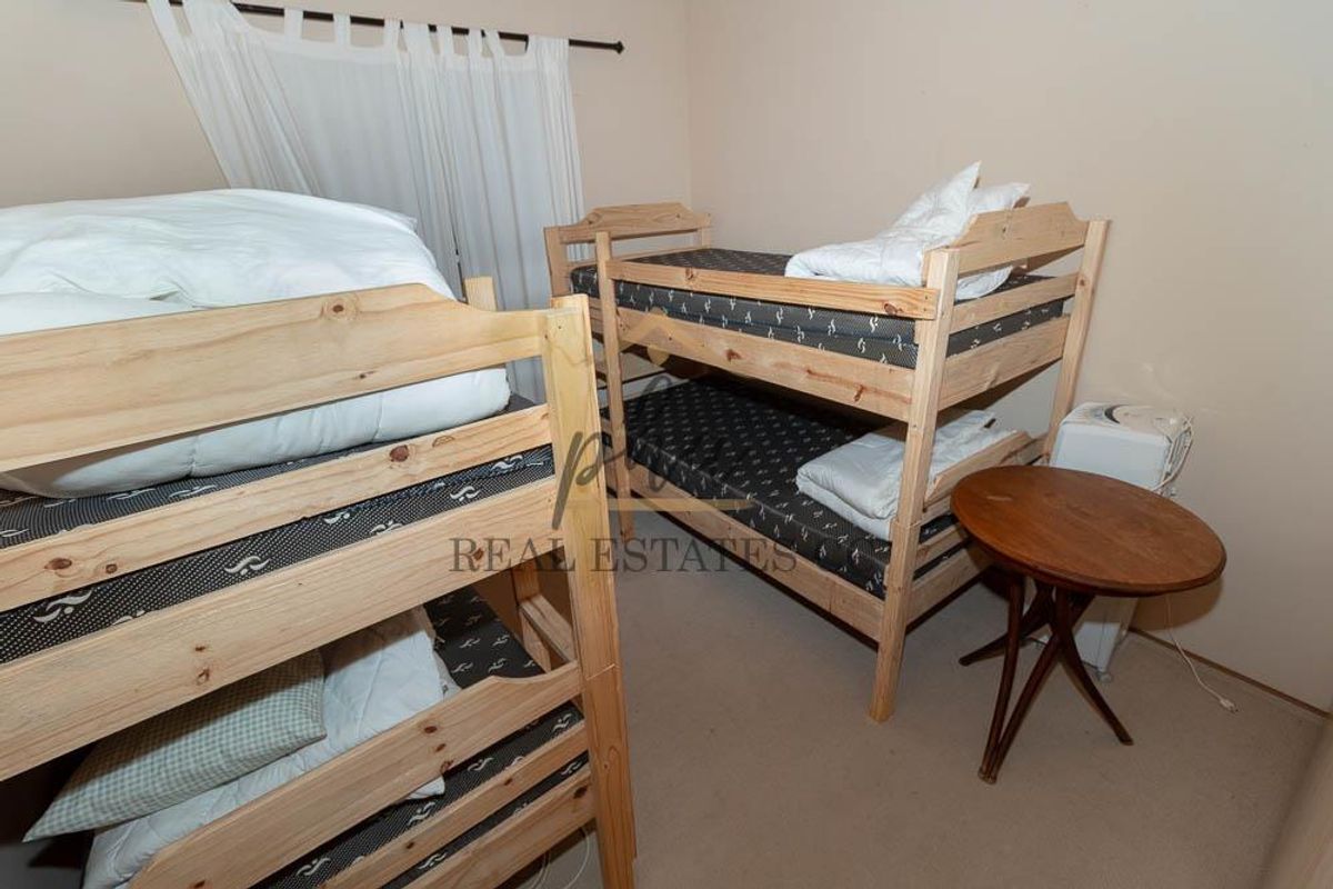 A bedroom featuring neutral wall finishes and carpeted flooring, currently configured with bunk beds.