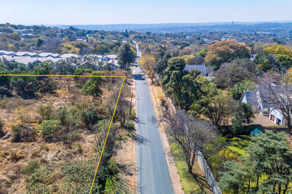 Aerial view of the vacant residential land plot showing its proximity to the street and surrounding neighborhood landscape.