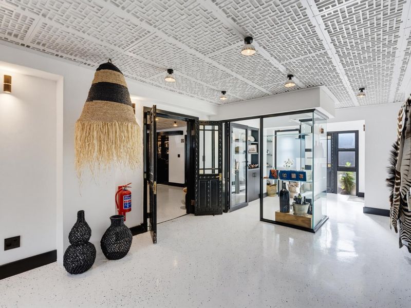 A modern, well-lit entry area featuring a unique decorative ceiling, polished terrazzo flooring, and a built-in glass display case.