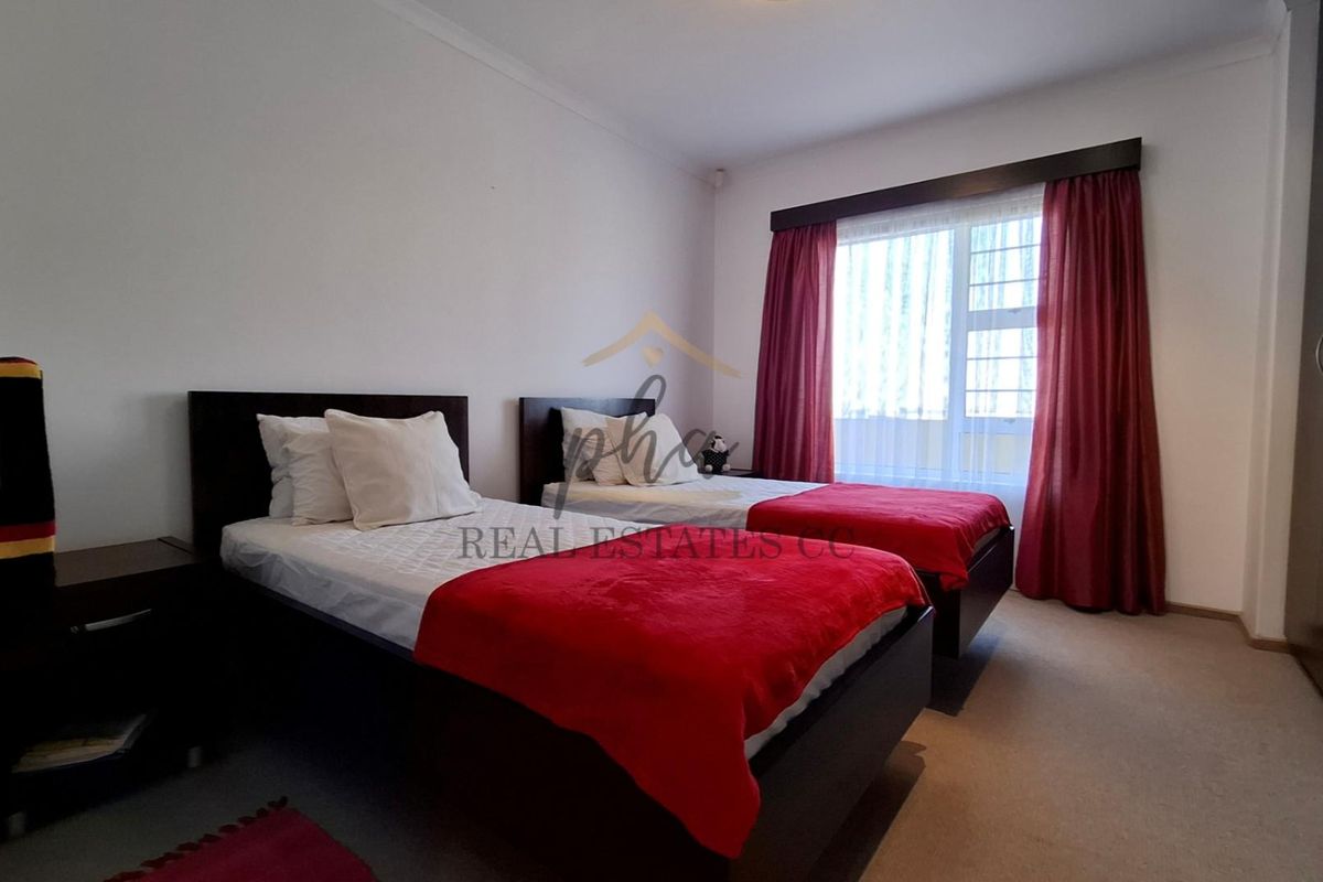 A bedroom featuring neutral walls, carpeted flooring, and a built-in wardrobe, providing a functional space with natural light from the window.
