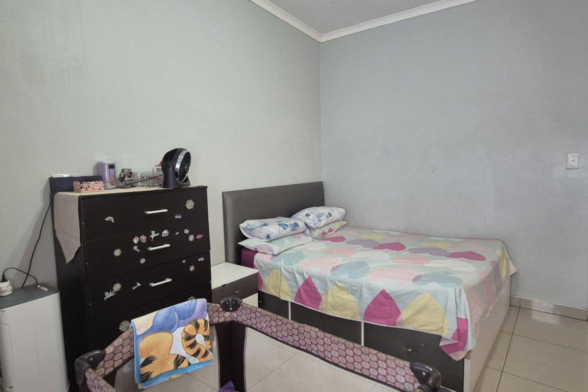 A standard bedroom featuring tiled flooring and neutral wall finishes, providing a functional living space.