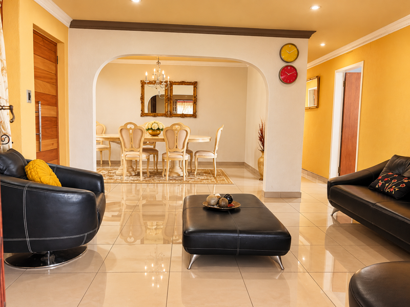 Spacious open-plan living and dining area featuring polished porcelain floor tiles, an elegant arched transition, and recessed lighting throughout.