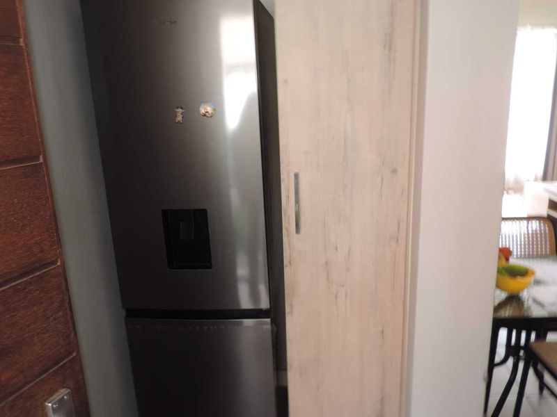 A kitchen area featuring built-in cabinetry and a tall pantry cupboard, providing functional storage space within the home.