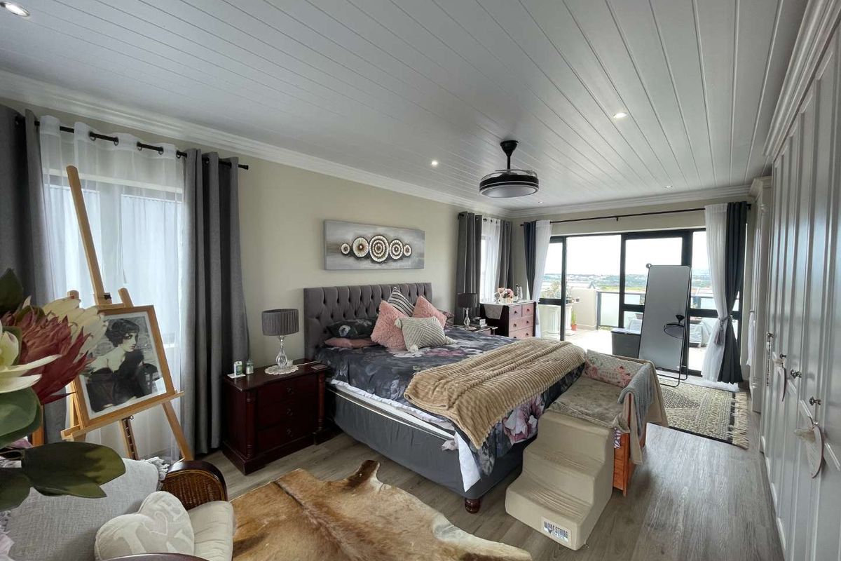 Spacious bedroom featuring a tongue and groove ceiling, recessed lighting, built-in cupboards, laminate flooring, and sliding glass doors leading to an outdoor area.