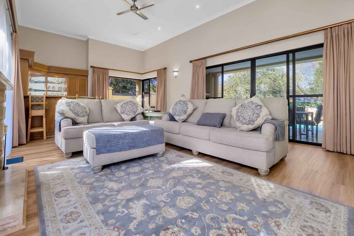 Spacious living room featuring high ceilings, a built-in bar, fireplace, and large sliding glass doors providing access to the outdoor area.