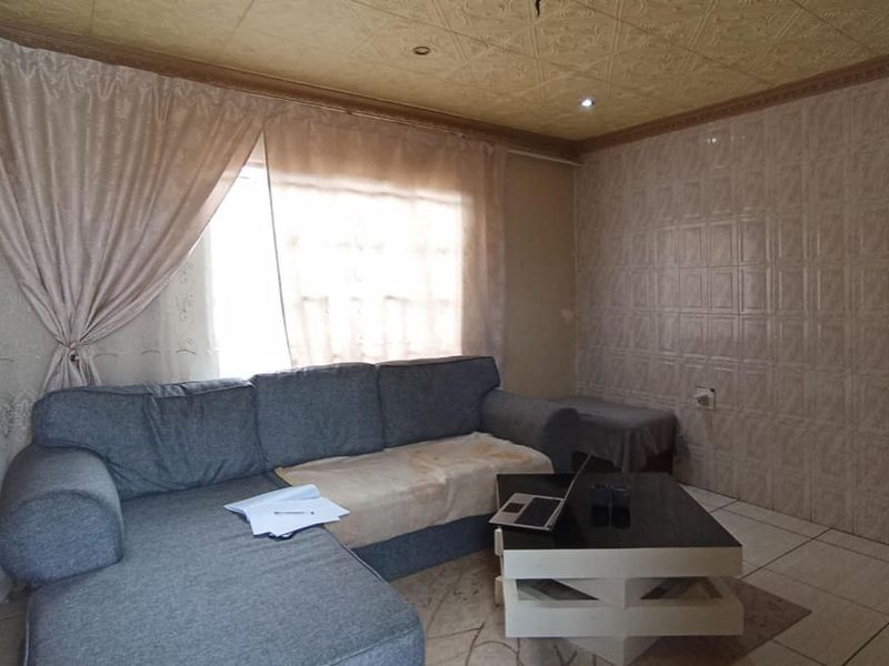 A living room featuring tiled wall finishes, tiled flooring, and a textured ceiling with recessed lighting.