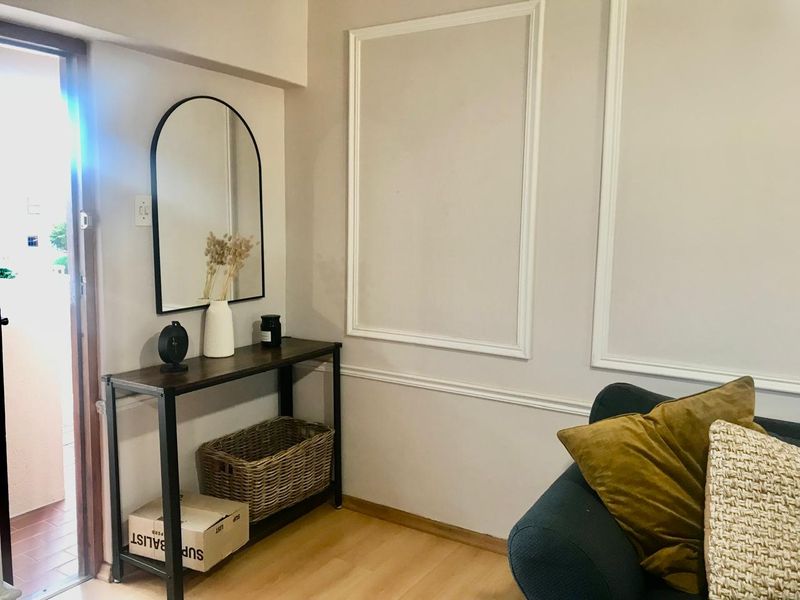An entry area featuring decorative wall molding and light-toned laminate flooring, providing a clean and welcoming transition space for the townhouse.