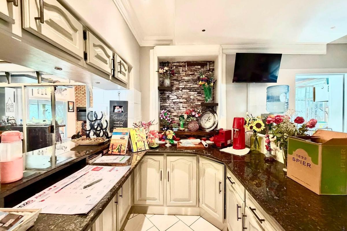 A kitchen area featuring granite countertops, built-in cabinetry, and a decorative stone veneer feature wall with recessed lighting.