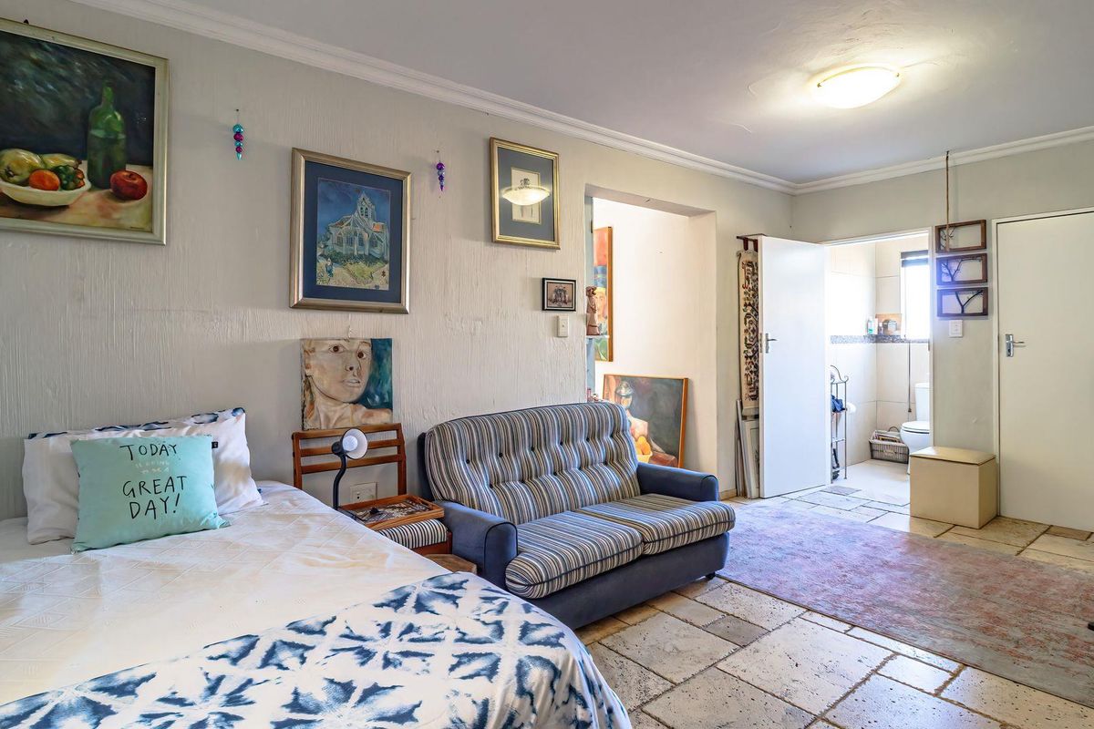 A bedroom featuring tiled flooring and direct access to an adjoining bathroom, offering a functional layout with neutral wall finishes.