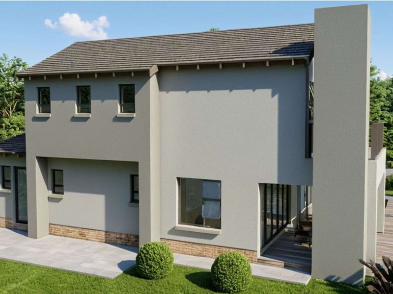 A rear view of a modern two-story house featuring a plastered facade, brick base, paved patio, and timber decking set within a landscaped garden.