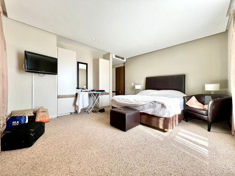 Spacious bedroom featuring built-in wardrobes, recessed lighting, and ducted air conditioning, offering a comfortable layout with neutral wall finishes.