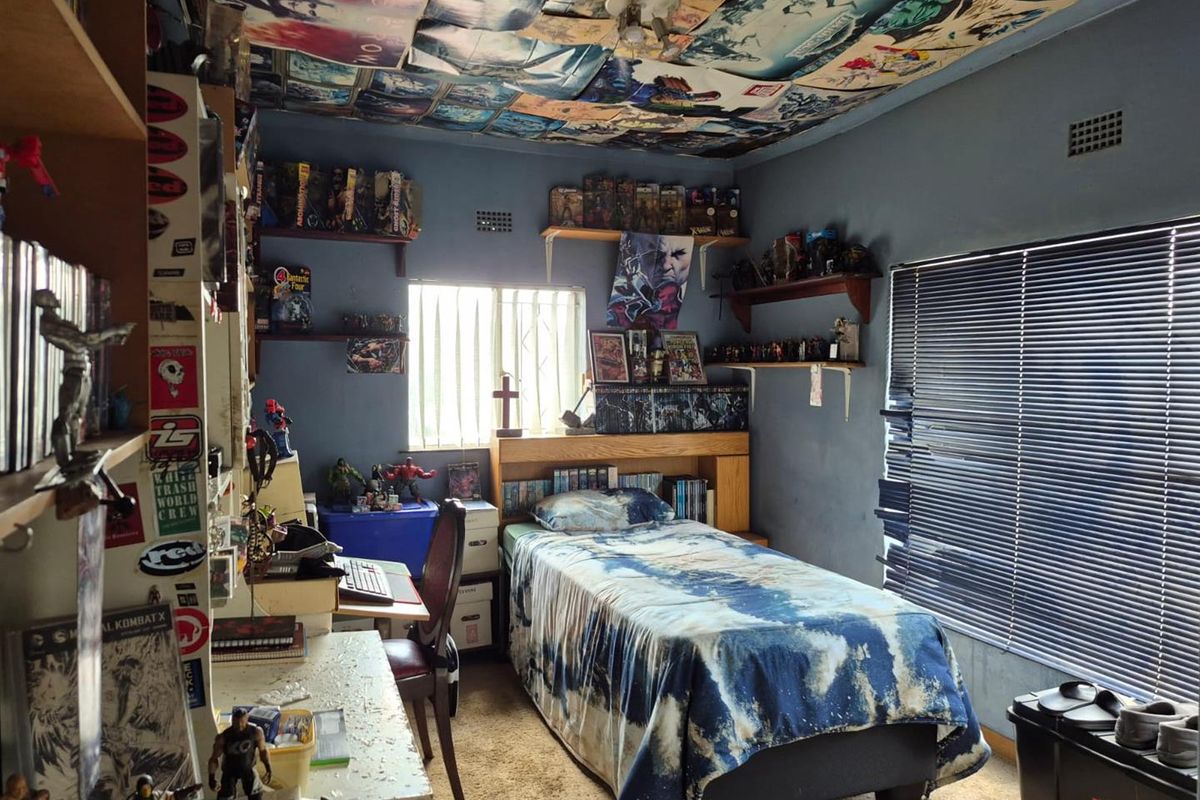 A bedroom featuring a single bed, built-in headboard, and window blinds. The room requires cosmetic updates to improve its overall condition and appeal.