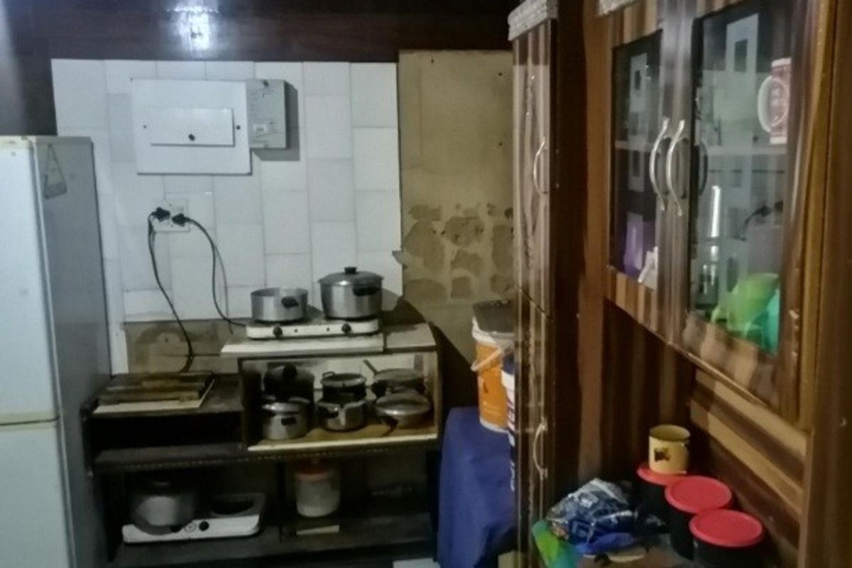 A dated kitchen area featuring built-in cabinetry and tiled splashbacks, currently showing signs of wear and requiring maintenance or renovation.