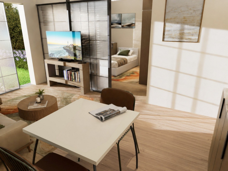 An open-plan living area featuring modern laminate flooring, a sliding glass room divider, and access to an outdoor patio space.