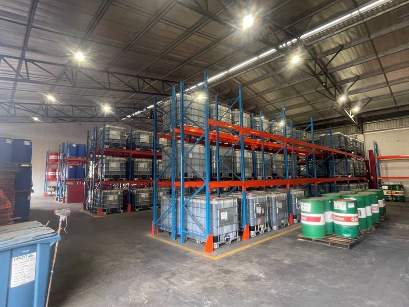 Spacious industrial warehouse facility featuring high-bay LED lighting, durable concrete flooring, and extensive heavy-duty steel racking systems for efficient storage.