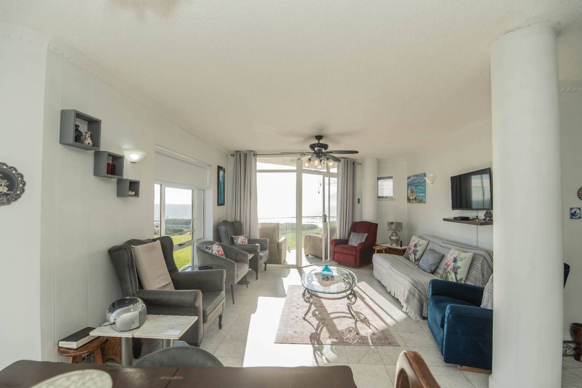 Spacious living room featuring tiled flooring, a ceiling fan, and large sliding glass doors that provide natural light and access to the outdoor area.