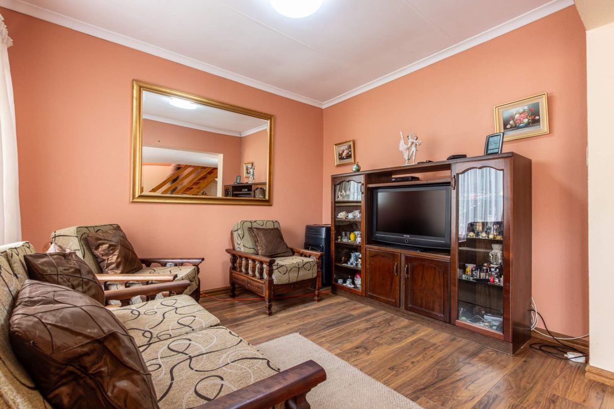 A living room featuring wood-look laminate flooring and painted walls, providing a functional space for relaxation.