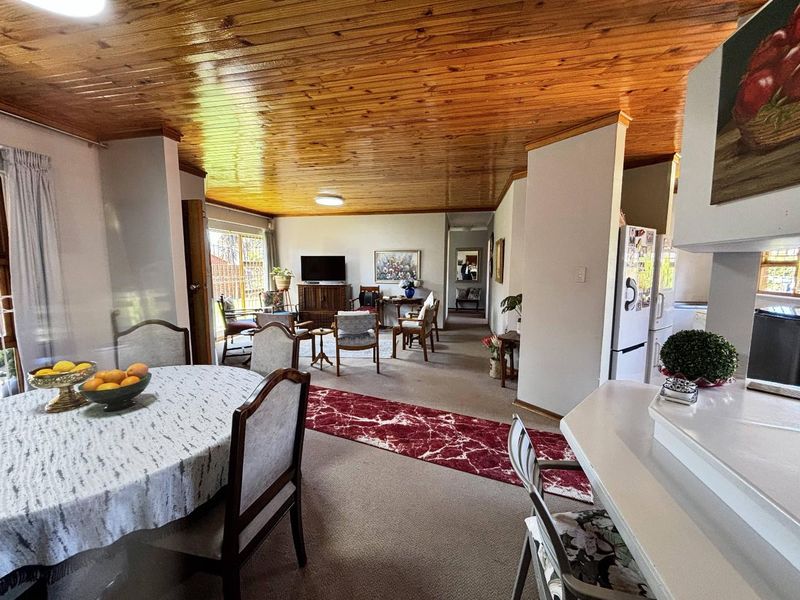 Open plan living and dining area featuring a distinctive timber ceiling, breakfast bar, and direct access to the outdoor space.