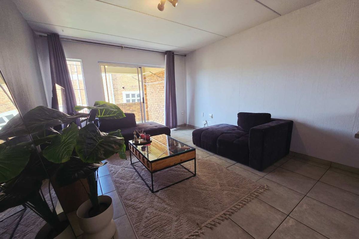 A living room featuring tiled flooring and a sliding glass door providing access to an outdoor area.