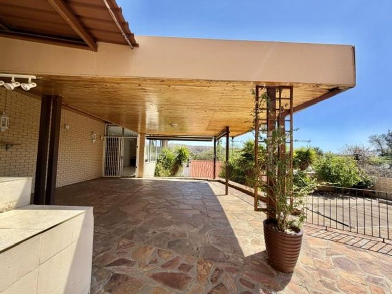 Spacious covered patio featuring natural stone paving and a timber-clad ceiling, offering an ideal outdoor entertainment area with views.