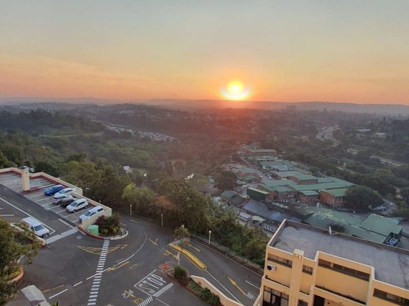 Elevated sunset view overlooking the surrounding landscape, parking facilities, and local infrastructure.