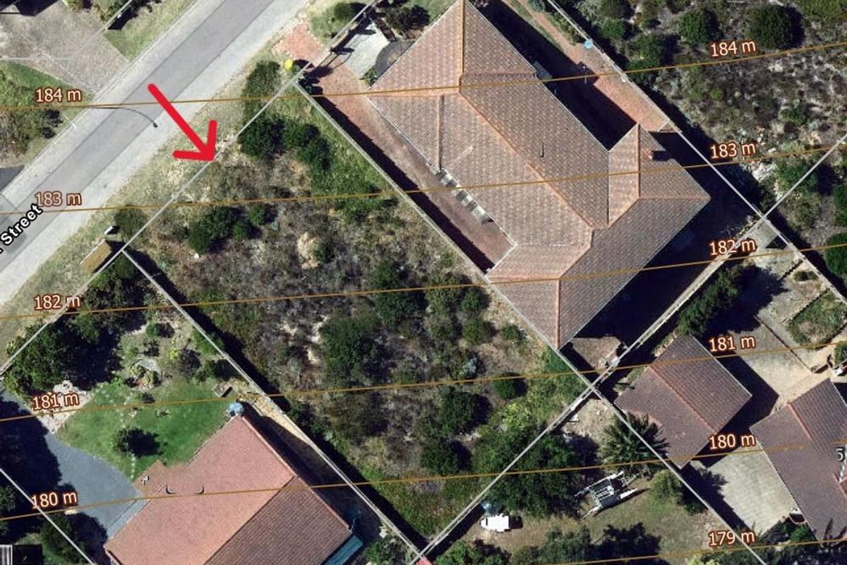 Aerial view of a vacant residential plot showing boundary lines, surrounding properties, and natural vegetation.