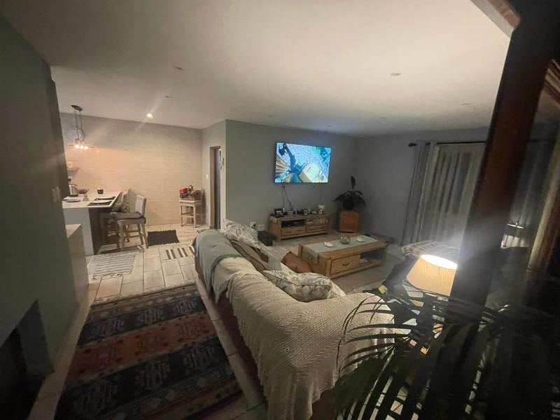 Open-plan living area featuring tiled flooring, recessed lighting, and a kitchen island, creating a functional and connected space for daily living.