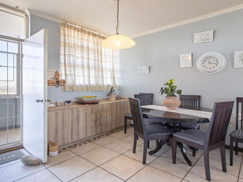 Dining area featuring built-in cabinetry, tiled flooring, and direct access to a balcony through a sliding glass door.