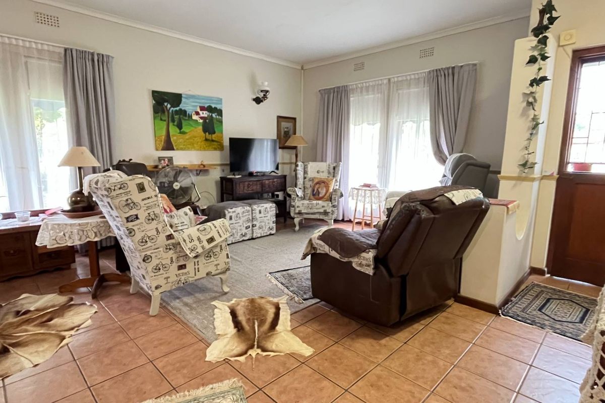 A spacious living room featuring tiled flooring and classic cornicing, offering a comfortable and functional layout for relaxation.