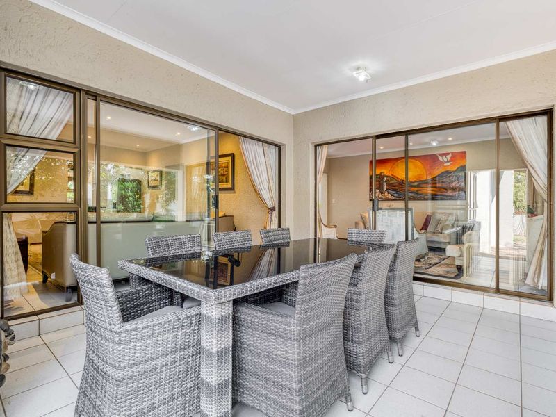 A covered patio area featuring tiled flooring and large sliding glass doors that provide seamless access to the interior living spaces.