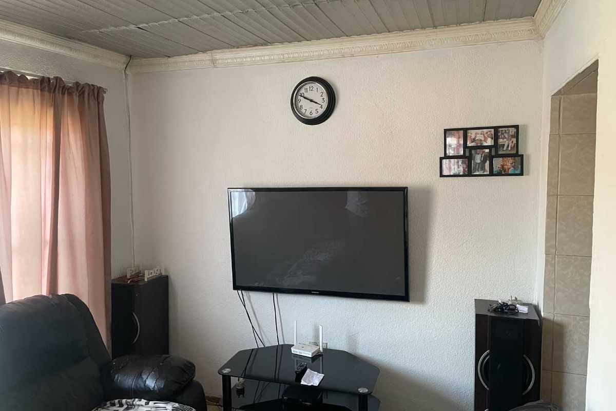 A living room area featuring a textured wall finish, corrugated metal ceiling panels, and crown molding detail.