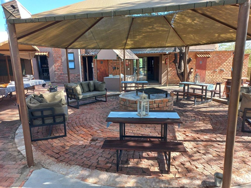 Outdoor tent lounge featuring a central fire pit and seating