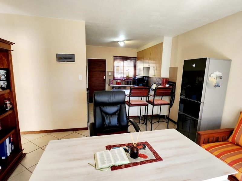 Open plan living and kitchen area featuring tiled flooring and functional built-in cabinetry.