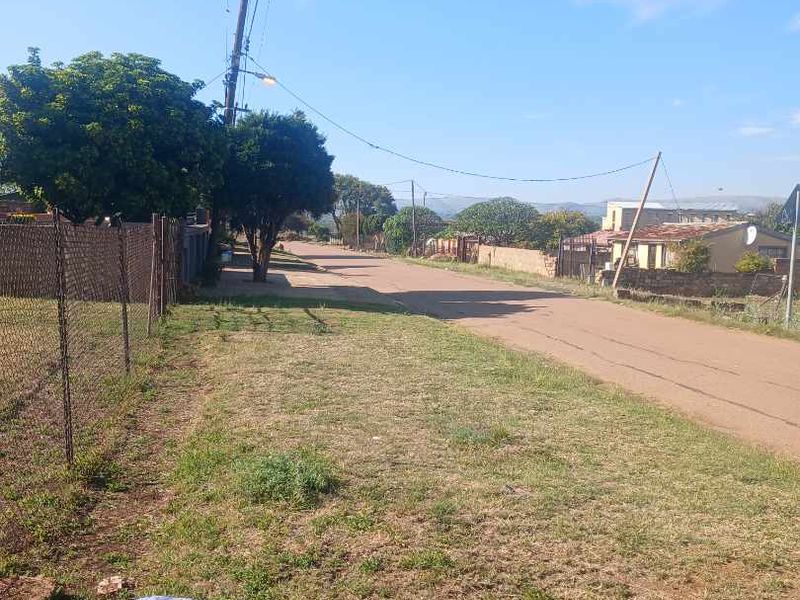 A view of the residential street showing the verge, chain-link fencing, and utility infrastructure in a suburban neighbourhood setting.