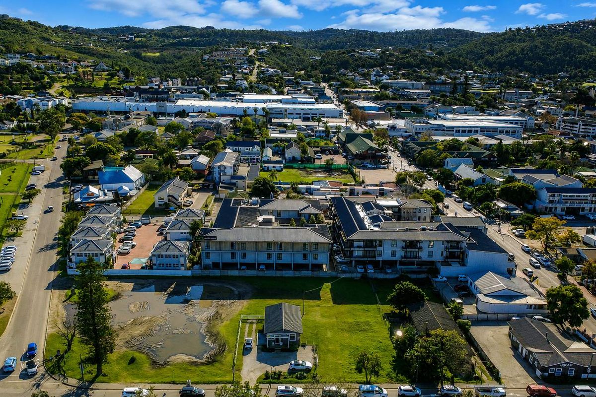 An aerial view of a residential vacant land plot situated within an established urban neighborhood, showcasing surrounding infrastructure and local development.