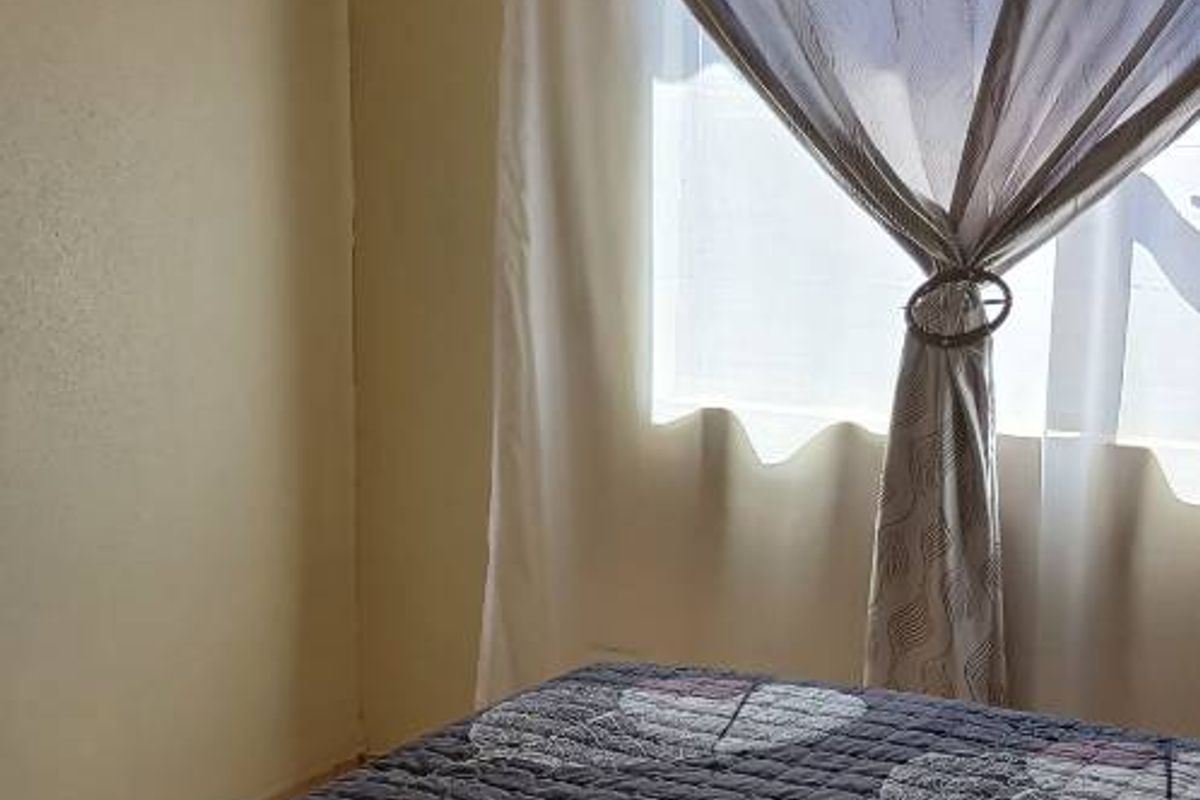 A bedroom featuring tiled flooring and recessed ceiling lighting, providing a functional and neutral space.