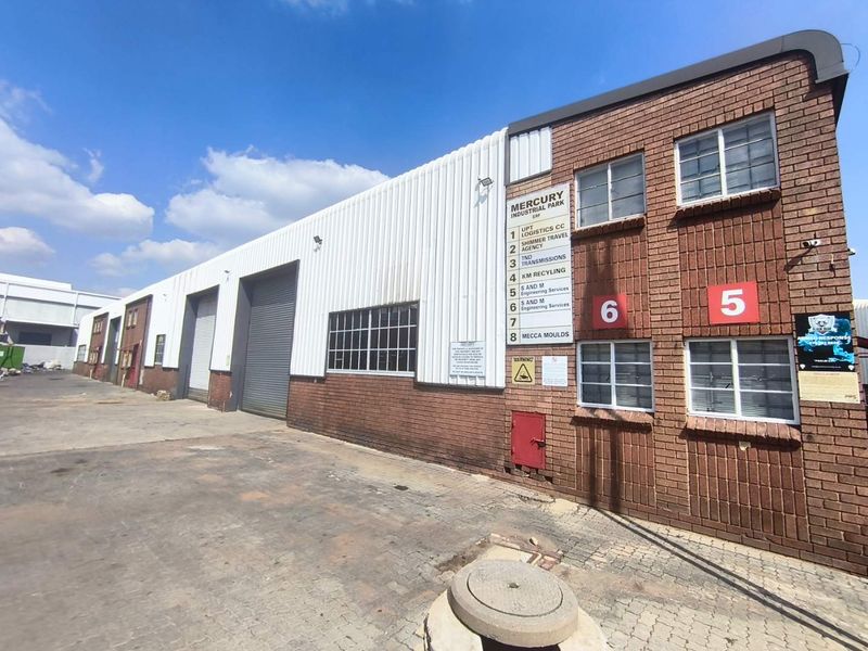 Exterior view of Mercury Industrial Park featuring brick and metal cladding, multiple roller shutter doors, and paved access area.