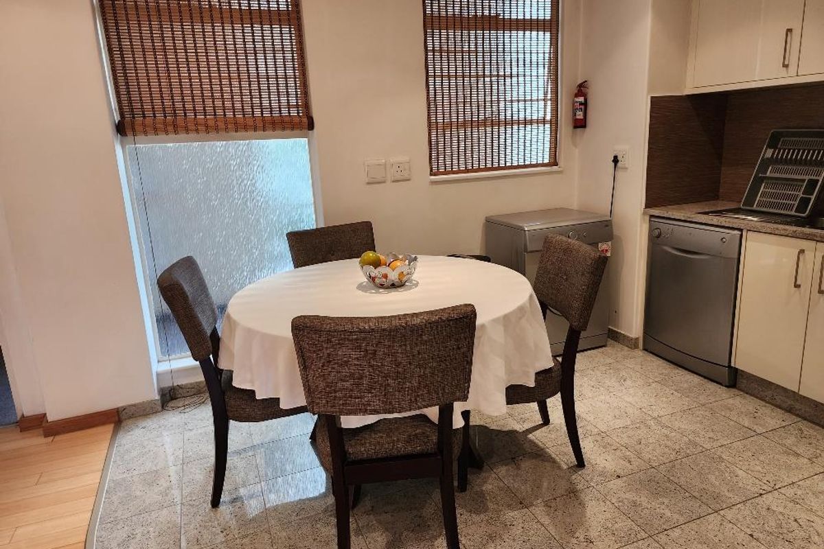 A functional kitchen area featuring built-in cabinetry, tiled flooring, and an integrated dishwasher, providing a practical space for meal preparation and dining.
