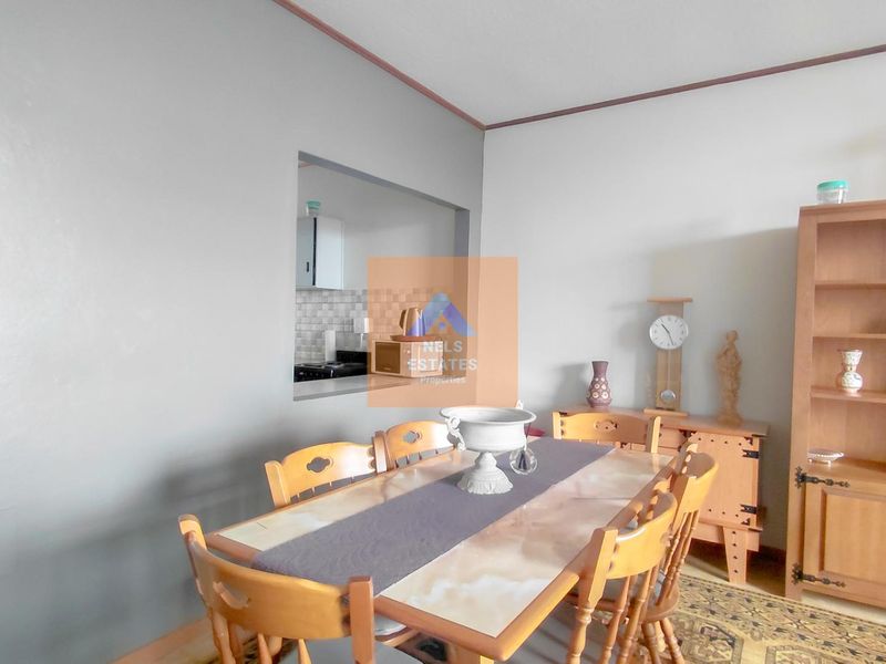 A dining room featuring a serving hatch connecting to the kitchen and decorative coving along the ceiling perimeter.